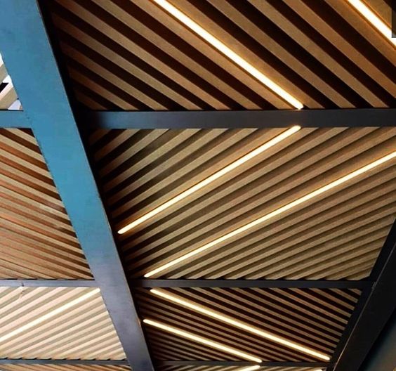 Отделка потолка 3D-панелями из ДПК позволяет легко осуществить оригинальную подсветку трубчатыми лампами и светодиодными лентами.