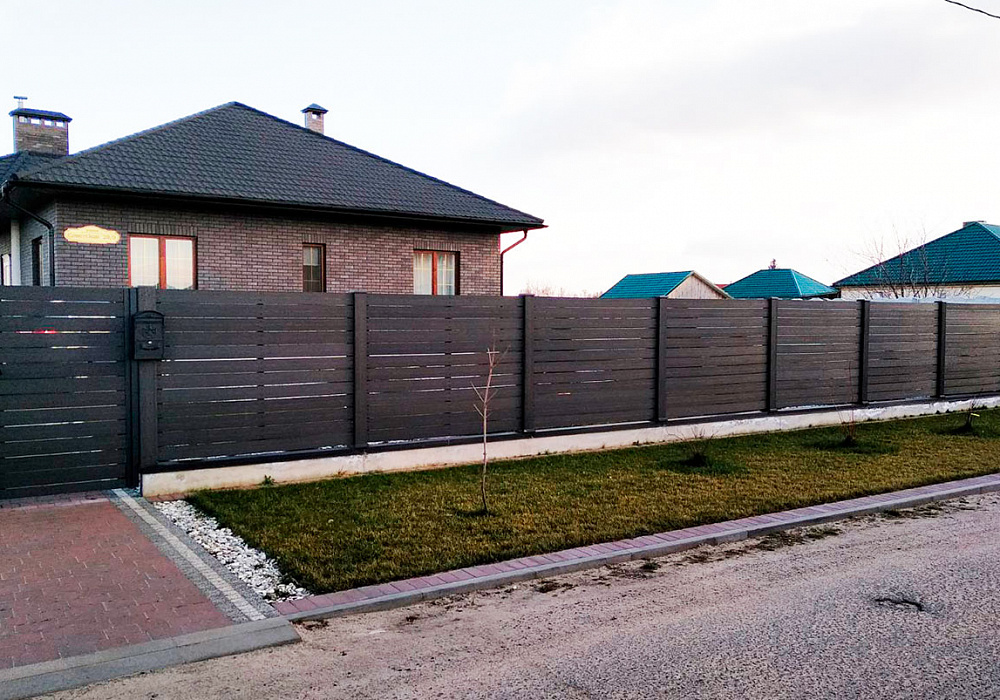 Забор из доски ДПК на участке частного дома.